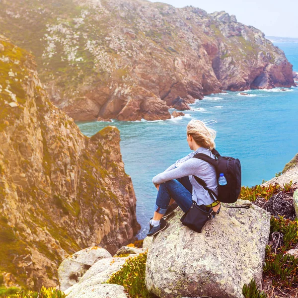 Turystyczna kobieta siedzi na przylądek Roca, Sintra, Portugalia — Zdjęcie stockowe
