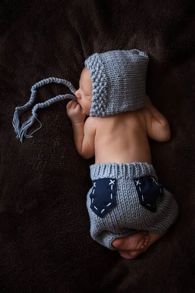 Neugeborenes im grauen Strickanzug schläft in schöner Pose — Stockfoto