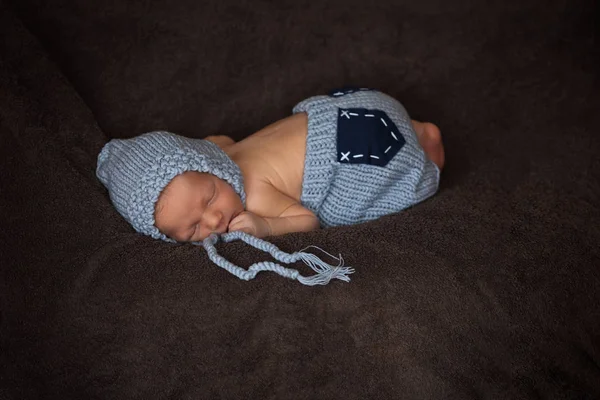 Neugeborenes im grauen Strickanzug schläft in schöner Pose — Stockfoto
