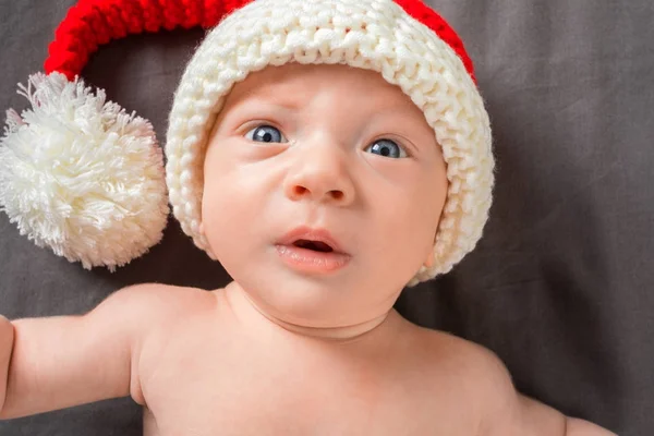 Neugeborenes Baby mit Weihnachtsmann-Mütze vor dunklem Hintergrund — Stockfoto