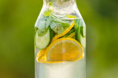 İçki limon ve nane ile yeşil çim zemin üzerine salatalık Detoks