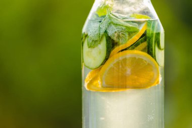 İçki limon ve nane ile yeşil çim zemin üzerine salatalık Detoks