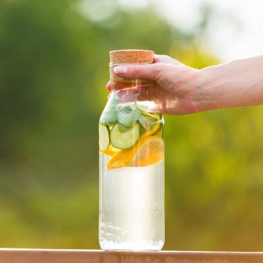 İçki limon ve nane ile yeşil çim zemin üzerine salatalık Detoks