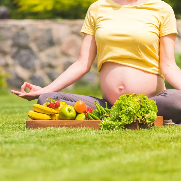 Беременная женщина, практикующая медитацию и отдых на природе — стоковое фото