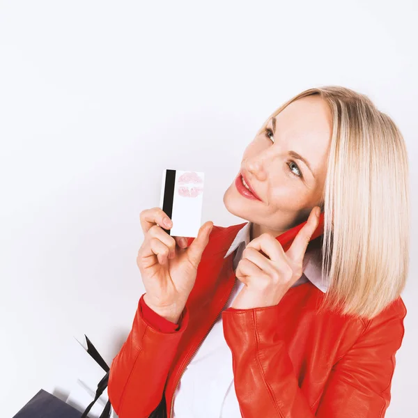 Alışveriş torbaları, cep telefonu ve kredi kartı ile genç kadın portresi. — Stok fotoğraf