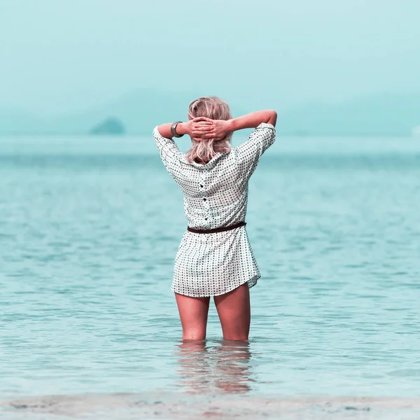 Mujer joven de pie en la rodilla en el agua en la playa de Tailandia y disfrutar de la vista — Foto de Stock