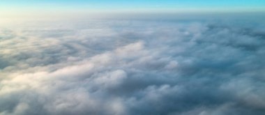 Yoğun sabah sisinin arka planında yükselen güneşten gelen sıcak bir ışık.