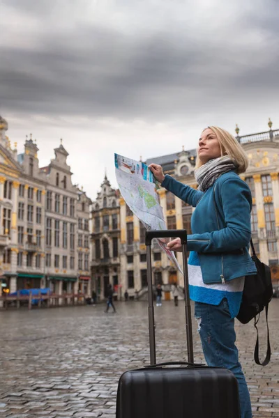 Mulher turista vai com uma mala na Grand Place em Bruxelas, Bélgica — Fotografia de Stock