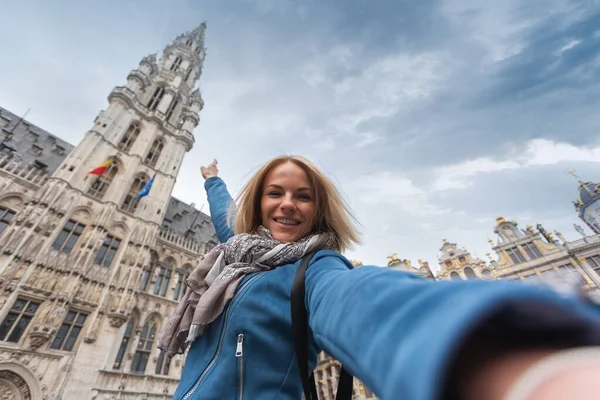 Una mujer toma una foto telefónica en el fondo del ayuntamiento en la plaza principal Grand place en Bruselas, Bélgica — Foto de Stock