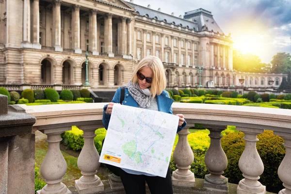 Uma mulher lê um mapa da cidade no contexto do Palácio Real em Bruxelas, Bélgica — Fotografia de Stock