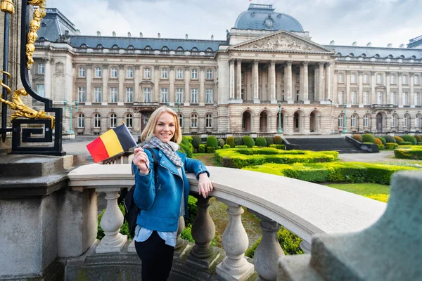 悬挂比利时国旗的妇女站在比利时布鲁塞尔王宫的背景下 — 图库照片