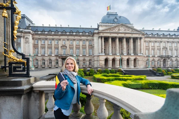 Mujer con la bandera de Bélgica se levanta contra el telón de fondo del Palacio Real en Bruselas, Bélgica — Foto de Stock
