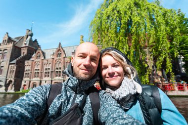 Genç çift, Belçika 'nın Bruges şehrinin ana caddesinde selfie çekiyor..