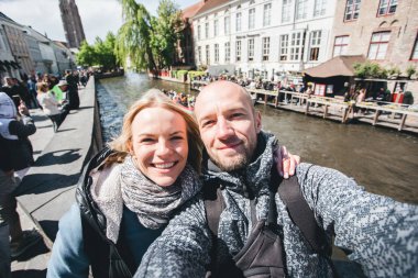 Genç çift, Belçika 'nın Bruges şehrinin ana caddesinde selfie çekiyor..