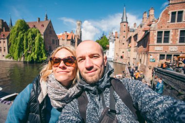 Genç çift, Belçika 'nın Bruges şehrinin ana caddesinde selfie çekiyor..