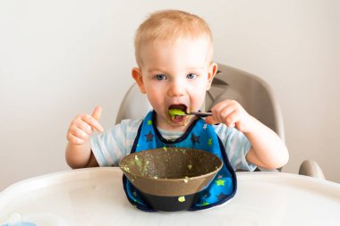 Küçük çocuk tabaktan püre yiyor..