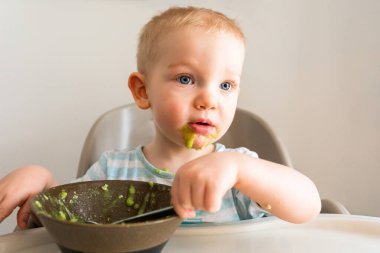 Küçük çocuk tabaktan püre yiyor..