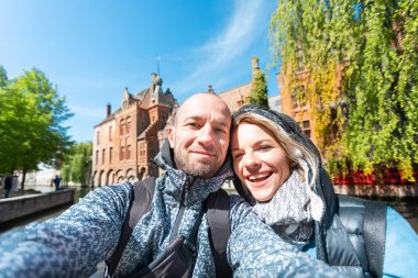Genç çift, Belçika 'nın Bruges şehrinin ana caddesinde selfie çekiyor..