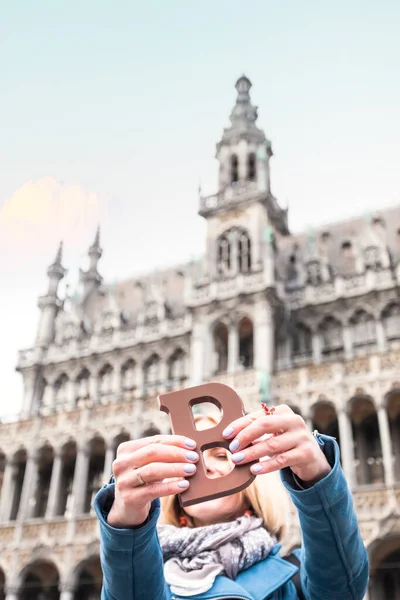 Mujer con barra de chocolate con leche de pie en el Grand Place en Bruselas en Bélgica . — Foto de Stock