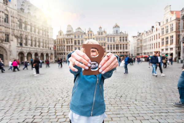Woman with milk chocolate bar standing on the Grand place in Brussels in Belgium. — 图库照片