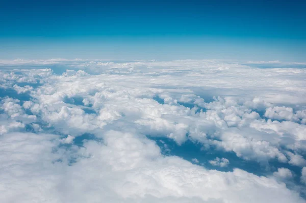 Sky with clouds from airplane window during flight. Royalty Free Stock Images