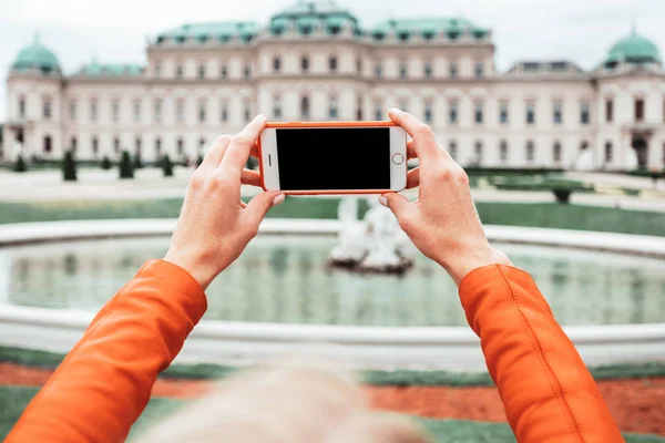 一位年轻快乐的女性游客在奥地利维也纳的贝尔韦代尔宫的背景下拍照 — 图库照片