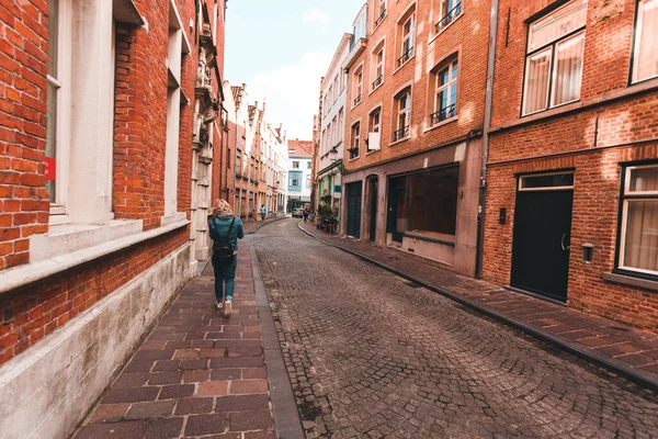 Žena kráčí prázdnou ulicí v belgickém Bruggách. — Stock fotografie