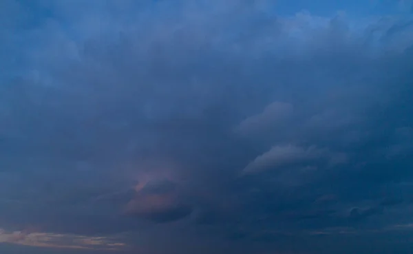 Cielo nublado oscuro con reflejos rojos al atardecer . —  Fotos de Stock