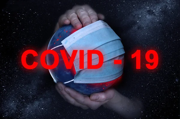 Les mains féminines tiennent la Terre dans un masque de protection médicale contre le ciel étoilé pendant l'épidémie Covide 19 ou coronavirus. Concept — Photo