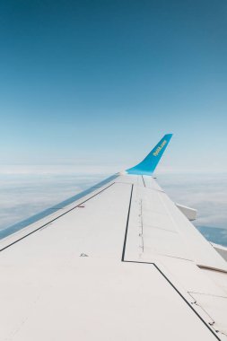Mavi gökyüzüne karşı uçarken bir uçağın kanadı