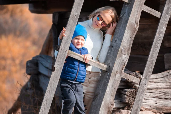 Mãe e menino estão perto da lâmina de um grande moinho velho no Museu Pirogovo no outono, Kiev, Ucrânia . — Fotografia de Stock