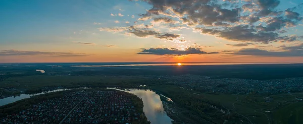 Panoramautsikt över naturlandskapet med gröna ängar och en flod vid solnedgången. — Stockfoto