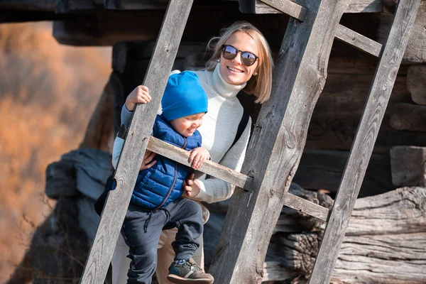 Mãe e menino estão perto da lâmina de um grande moinho velho no Museu Pirogovo no outono, Kiev, Ucrânia . — Fotografia de Stock