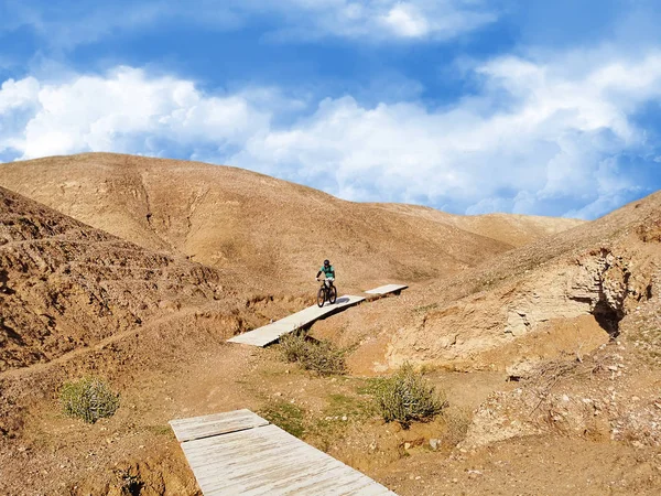 Mountain biker rides on wooden bridges — Stock Photo, Image