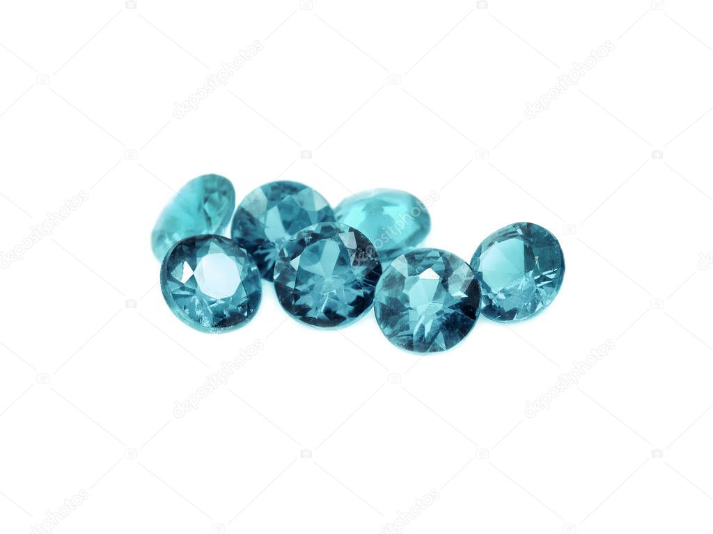 Seven aquamarines diamond cut gems on a white background.