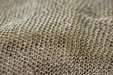 Zincir zırhı gibi görünen altın bir ağ şeklinde güzel bir kumaş.