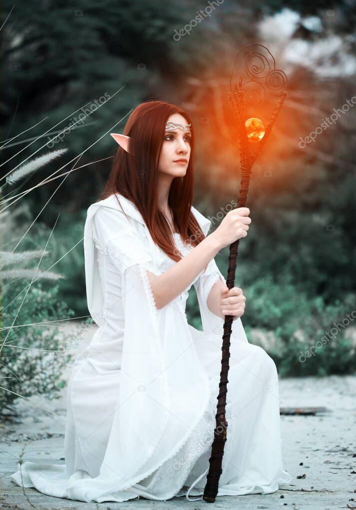 a girl with elven ears in a white dress walks through the woods and holds in her hands a magic staff, glowing