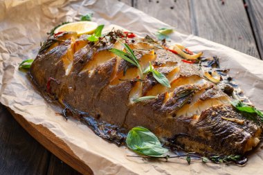 Baharatlarla dolu fırında balık, limon ve fesleğen.