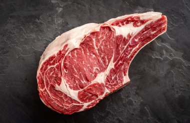 raw cowboy steak on stone background, prime rib eye on bone, top clipart