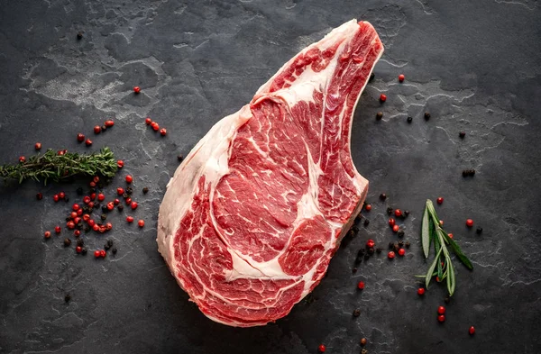 Rohes Cowboy-Steak mit Gewürzen auf Steinhintergrund, Prime Rib — Stockfoto