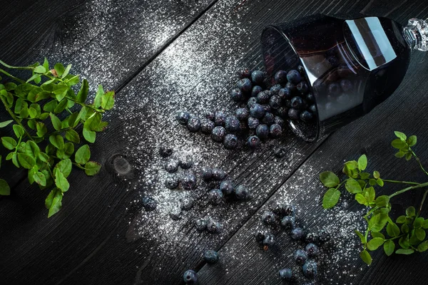 Organic fresh blueberries in glass Cup on black wooden backgroun — Stock Photo, Image