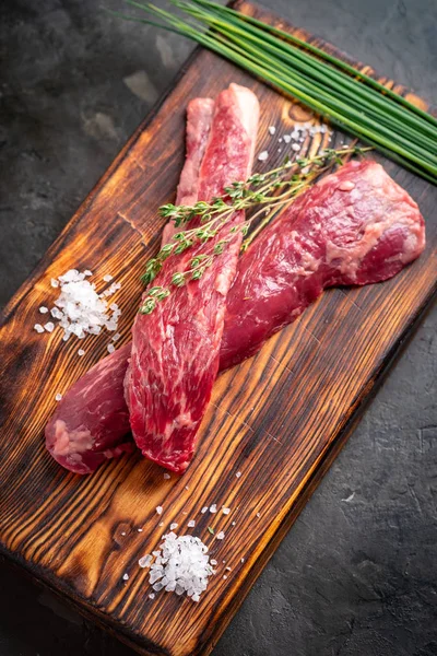 Dos piezas de carne cruda para asar a la parrilla en un tablero de madera — Foto de Stock