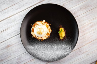 Siyah tabakta kremalı elmalı turta.