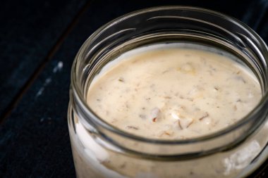 Koyu ahşap arka planda cam bir kasede ev yapımı organik mantar sosu, et yemekleri için baharat.