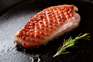 Kızarmış ördek göğsü. Siyah tavada altın kabuklu..