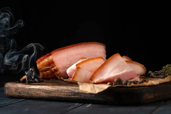 Smoked pork belly with a whole piece of smoke and sliced on a wooden Board