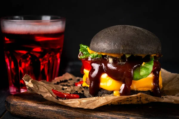 Hambúrguer Preto Com Queijo Tomate Molho Churrasco Pão Preto Papel — Fotografia de Stock