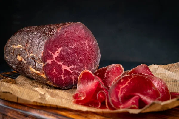 Yarım tütsülenmiş Bresaola ve doğrama tahtasının parçaları. İtalyan Antipasti, köy tarzı.