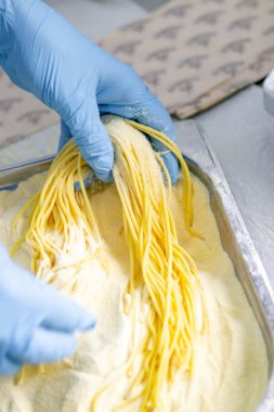 Makarna üretim süreci. Mutfakta taze spagetti üretimi.