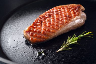 Kızarmış ördek göğsü. Siyah tavada altın kabuklu..